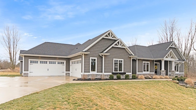 craftsman-style home with an attached garage, concrete driveway, and a front yard