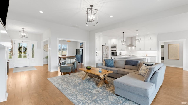 living room with a chandelier, recessed lighting, visible vents, baseboards, and light wood finished floors