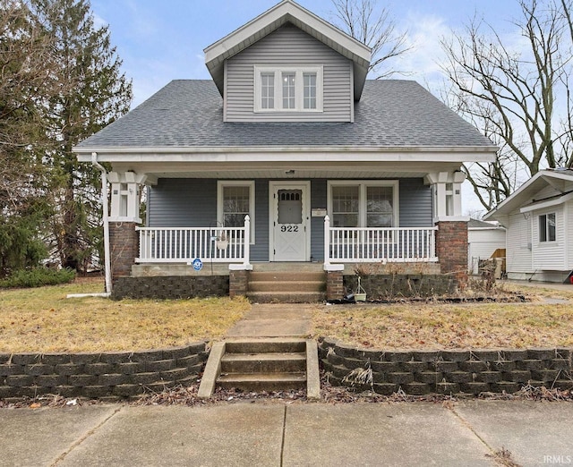 bungalow-style home featuring a shingled roof and a porch