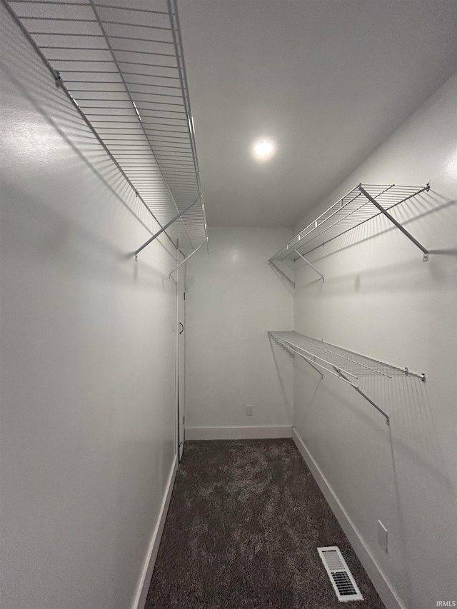 walk in closet with dark carpet and visible vents