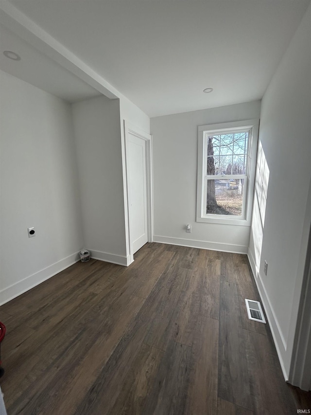 unfurnished bedroom featuring baseboards, visible vents, and dark wood-type flooring