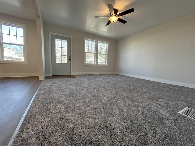 interior space featuring a ceiling fan, visible vents, and baseboards