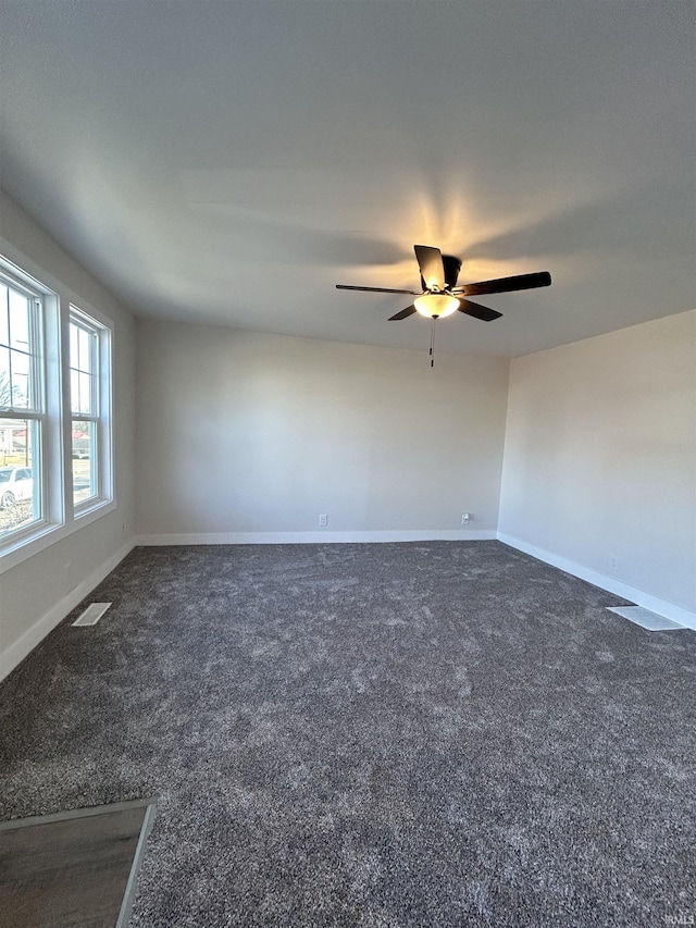 carpeted spare room featuring baseboards and a ceiling fan