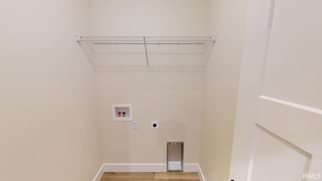 clothes washing area with laundry area, baseboards, light wood-style flooring, hookup for a washing machine, and hookup for an electric dryer