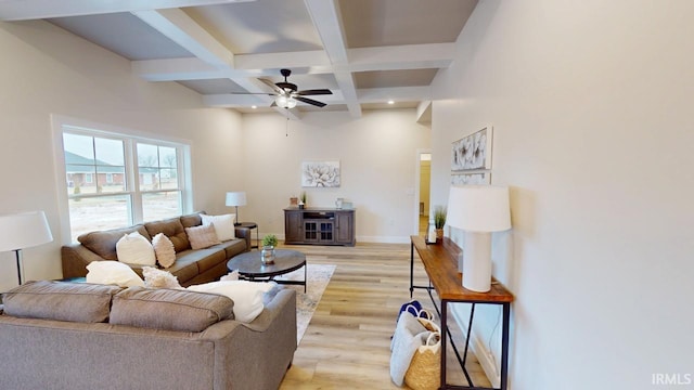 living room featuring light wood finished floors, ceiling fan, coffered ceiling, beamed ceiling, and baseboards