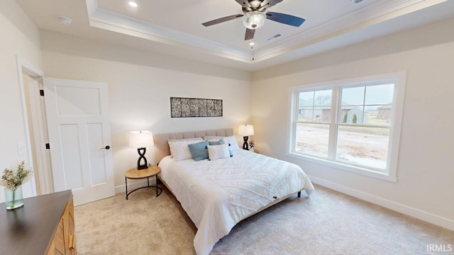 bedroom with a tray ceiling, light colored carpet, and crown molding