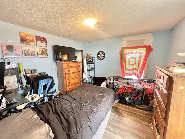 bedroom featuring a textured ceiling and wood finished floors