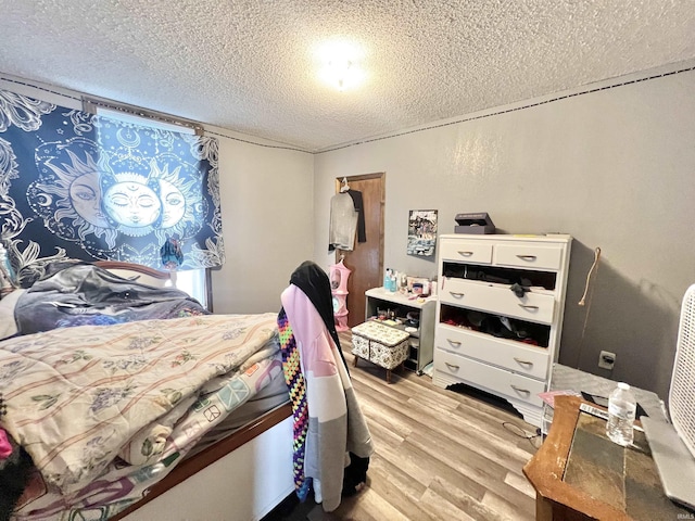 bedroom with a textured ceiling and light wood finished floors