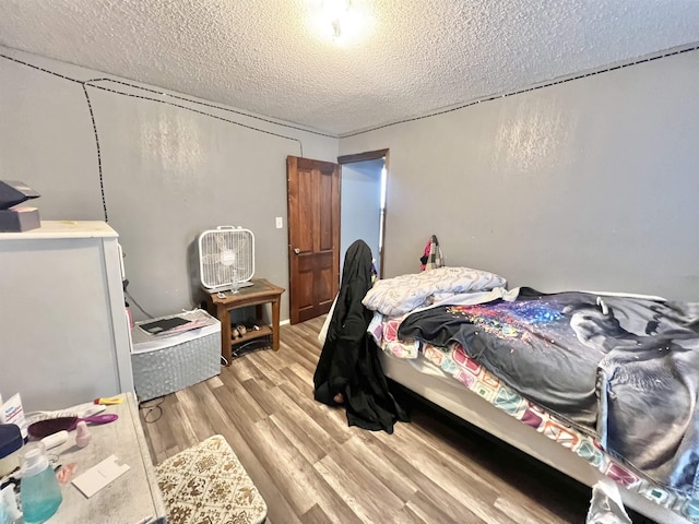 bedroom featuring a textured ceiling and light wood-style flooring