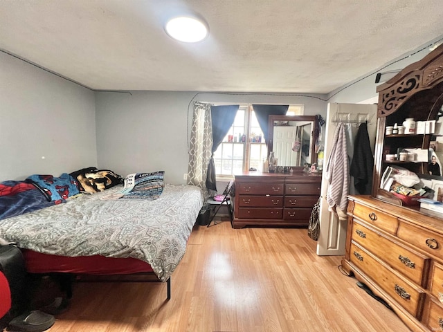 bedroom featuring a textured ceiling and light wood finished floors