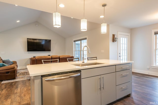 kitchen with a sink, open floor plan, light countertops, stainless steel dishwasher, and dark wood-style floors