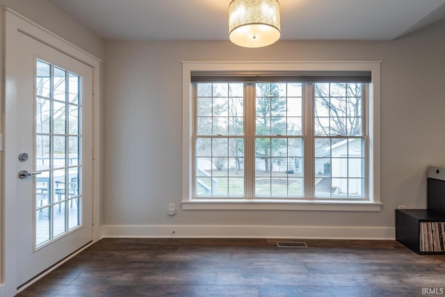 doorway to outside with dark wood-type flooring, plenty of natural light, and visible vents