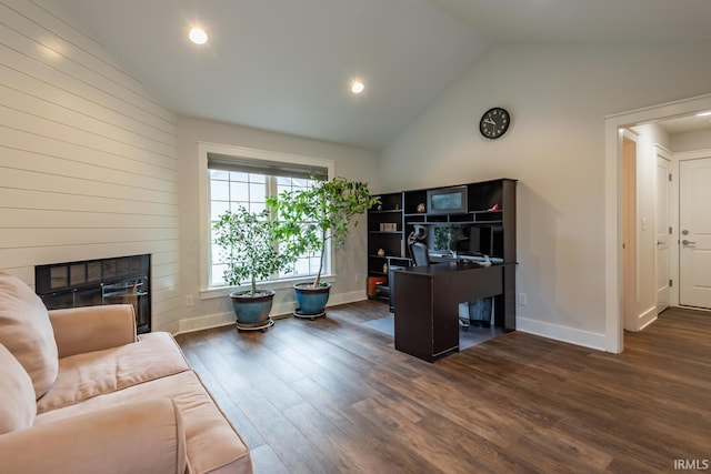 office with dark wood-style floors, a glass covered fireplace, vaulted ceiling, and baseboards