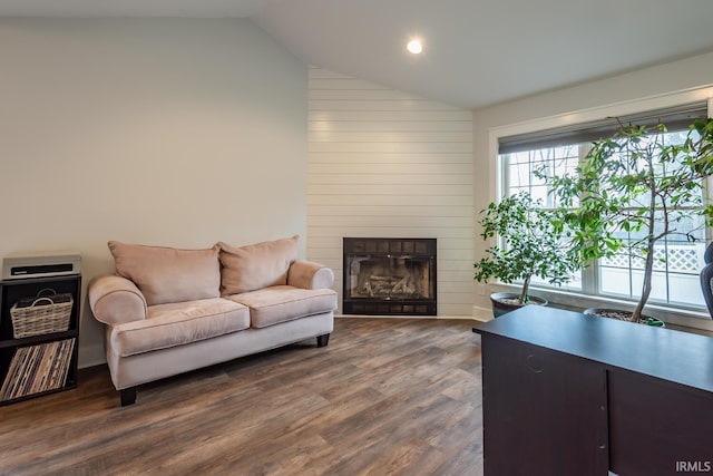 living room with dark wood-style floors, a large fireplace, and vaulted ceiling