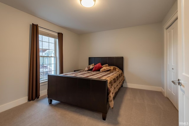 bedroom with baseboards and light colored carpet