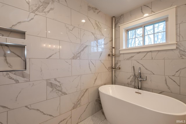 full bathroom with a freestanding tub and tile walls