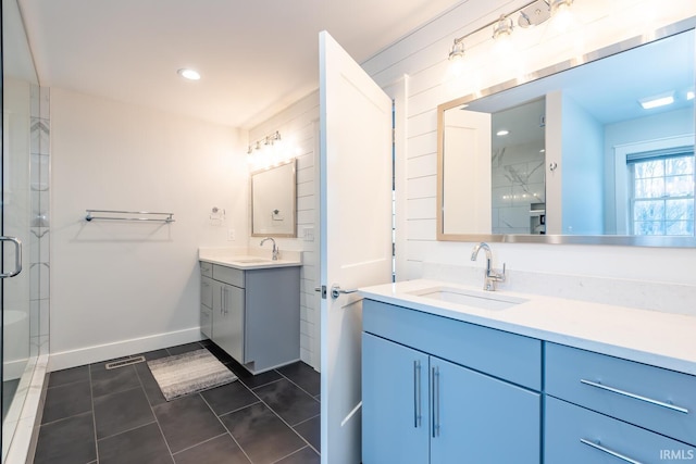 bathroom with two vanities, a sink, a shower stall, and tile patterned floors