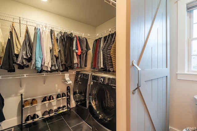 interior space featuring tile patterned flooring, visible vents, and washer and clothes dryer