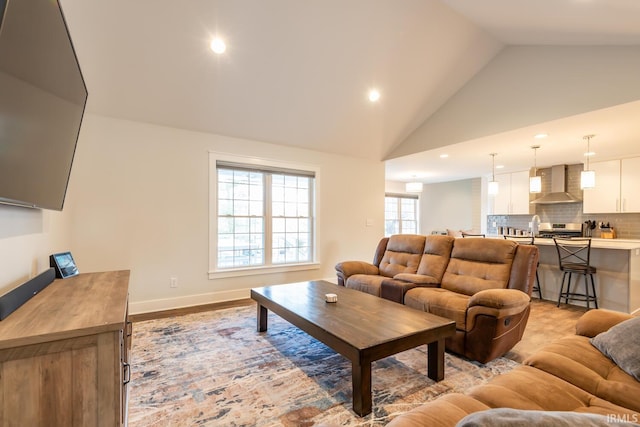 living room featuring baseboards, high vaulted ceiling, and recessed lighting