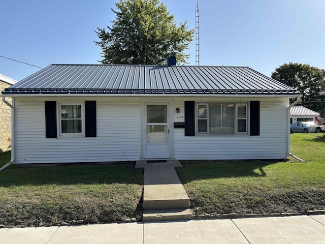 view of front of house with metal roof, a standing seam roof, and a front yard