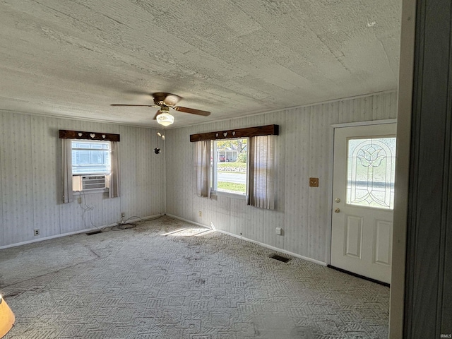 unfurnished room with baseboards, visible vents, ceiling fan, cooling unit, and carpet floors