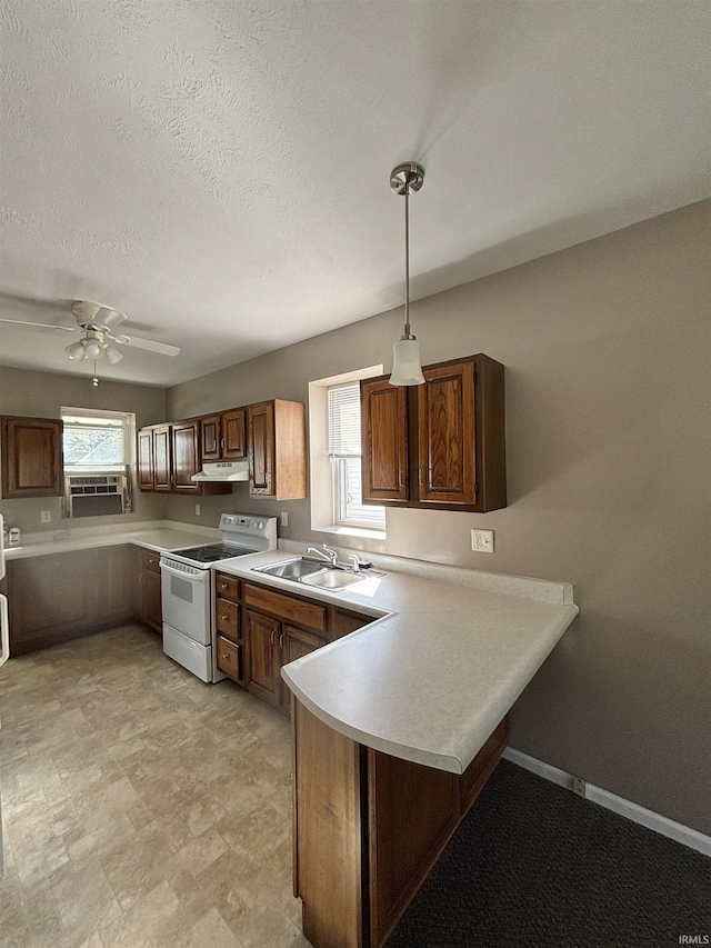 kitchen featuring white electric range oven, light countertops, a sink, a peninsula, and under cabinet range hood