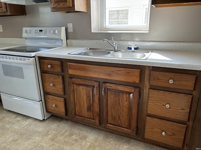 kitchen with white electric range oven, range hood, light countertops, and a sink