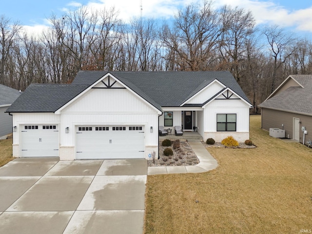 modern inspired farmhouse featuring brick siding, roof with shingles, an attached garage, a front yard, and driveway