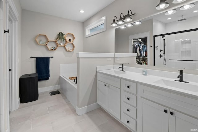 bathroom with a stall shower, a garden tub, a sink, and a spacious closet