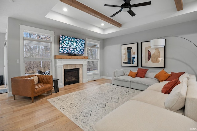 living room featuring a wealth of natural light, recessed lighting, beam ceiling, and light wood-style floors