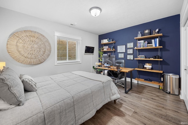 bedroom with visible vents and wood finished floors