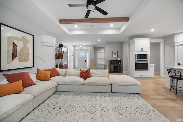 living room featuring beam ceiling, recessed lighting, light wood-style floors, a ceiling fan, and baseboards