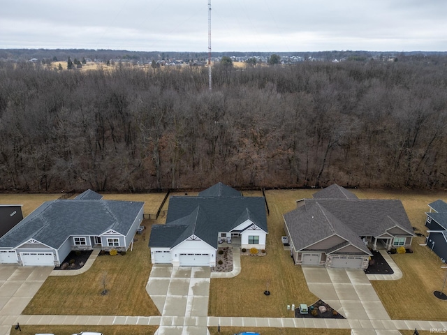 drone / aerial view featuring a residential view and a wooded view