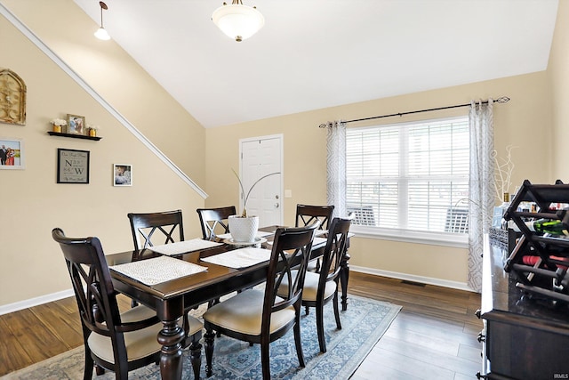 dining area with lofted ceiling, visible vents, baseboards, and wood finished floors