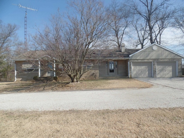 ranch-style home featuring driveway, a chimney, and an attached garage