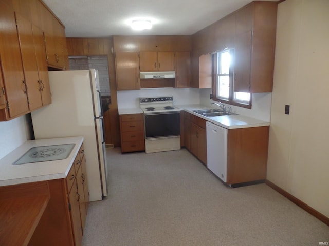 kitchen featuring light countertops, brown cabinetry, a sink, white appliances, and under cabinet range hood