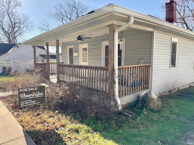 view of front of home featuring a porch, ceiling fan, and a chimney