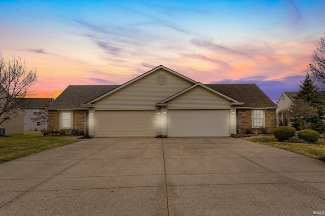 single story home featuring an attached garage, a yard, concrete driveway, and brick siding