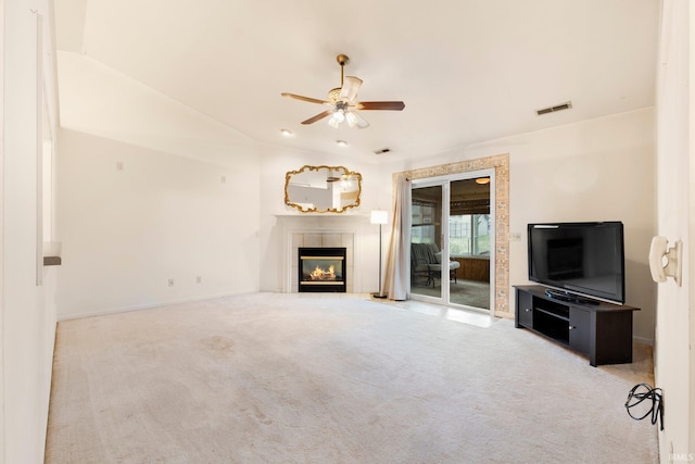 unfurnished living room with carpet, visible vents, a ceiling fan, vaulted ceiling, and a tile fireplace