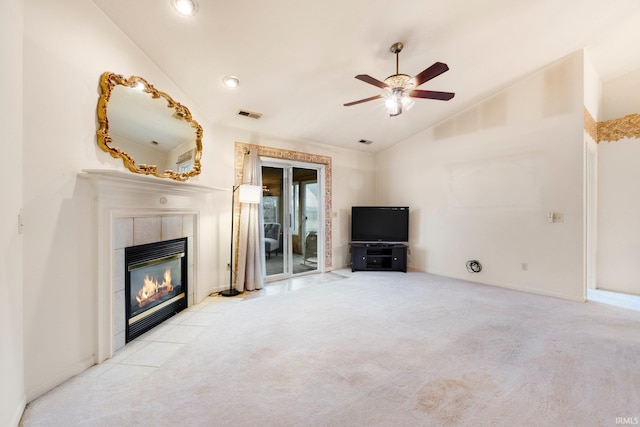 unfurnished living room with carpet, visible vents, a ceiling fan, vaulted ceiling, and a tile fireplace