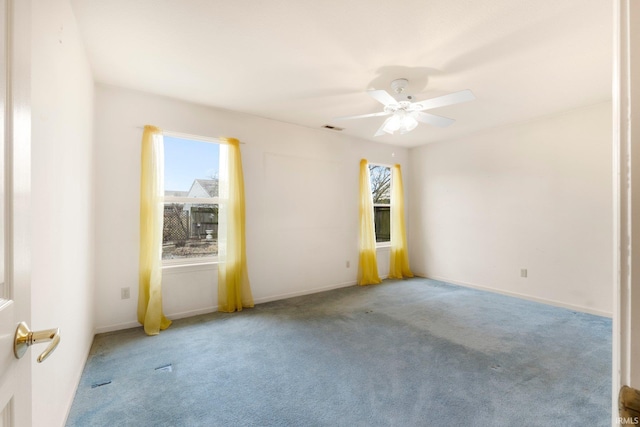 carpeted spare room featuring visible vents, ceiling fan, and baseboards