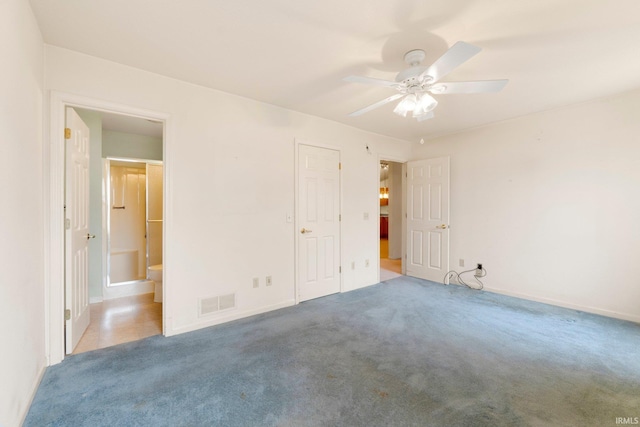 unfurnished bedroom with visible vents, baseboards, ensuite bath, ceiling fan, and carpet floors