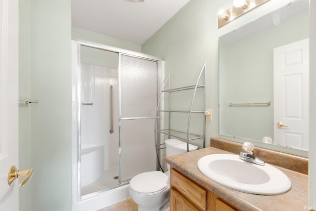 bathroom with a stall shower, vanity, and toilet