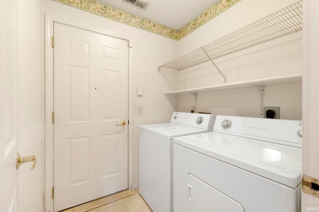 clothes washing area featuring laundry area, visible vents, and washing machine and clothes dryer