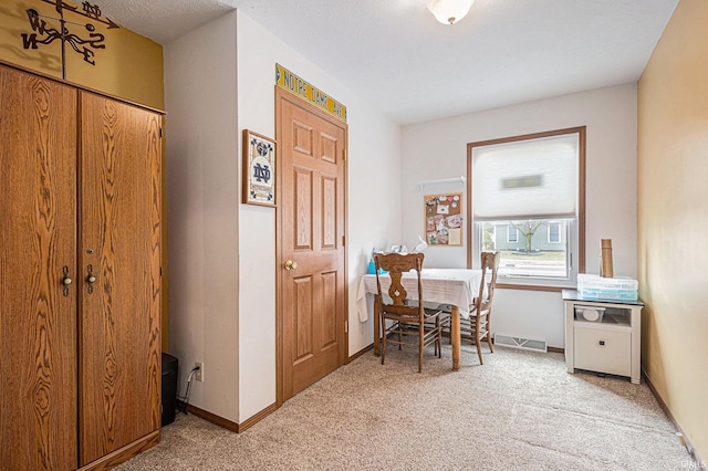 dining area with light carpet, visible vents, and baseboards