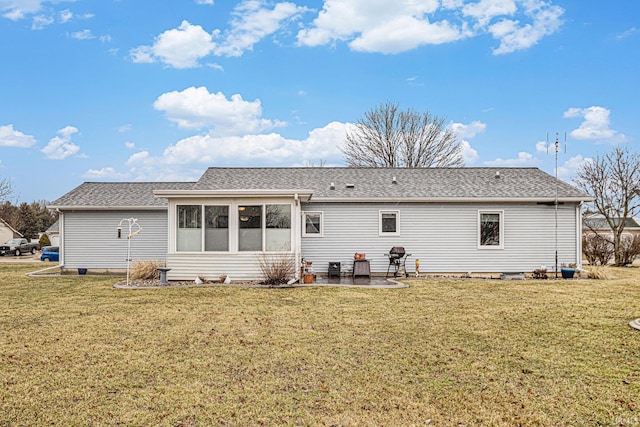 rear view of property with a yard, a sunroom, a patio, and a shingled roof