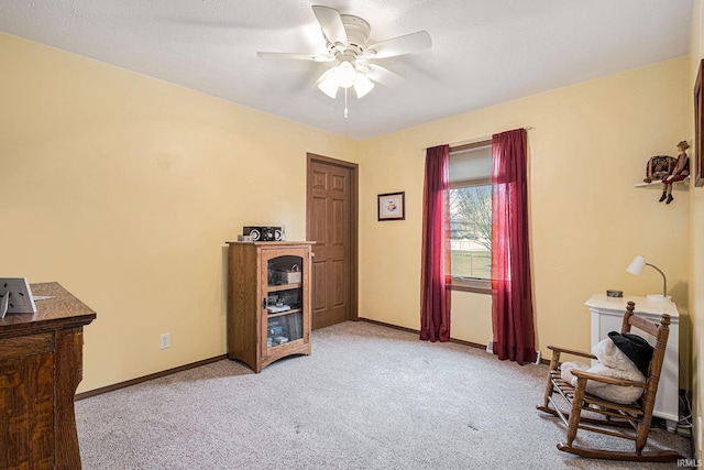 interior space with a ceiling fan, light colored carpet, and baseboards