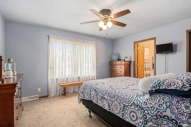 bedroom with a ceiling fan, a textured ceiling, baseboards, and carpet flooring