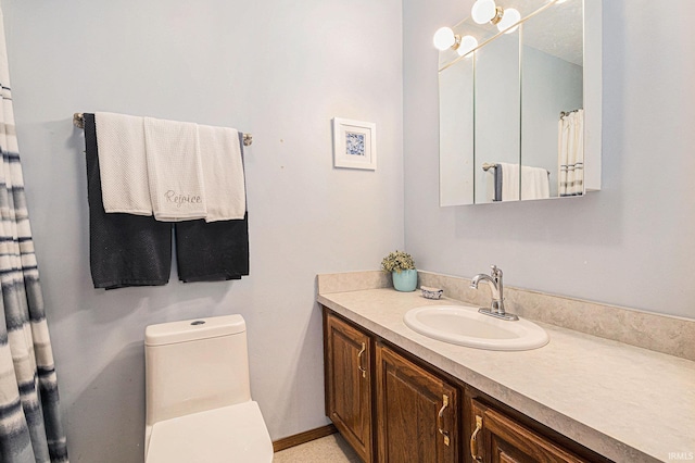 bathroom with baseboards, vanity, and toilet