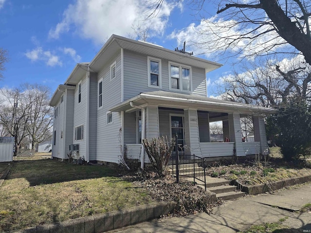 american foursquare style home featuring a porch and a front yard